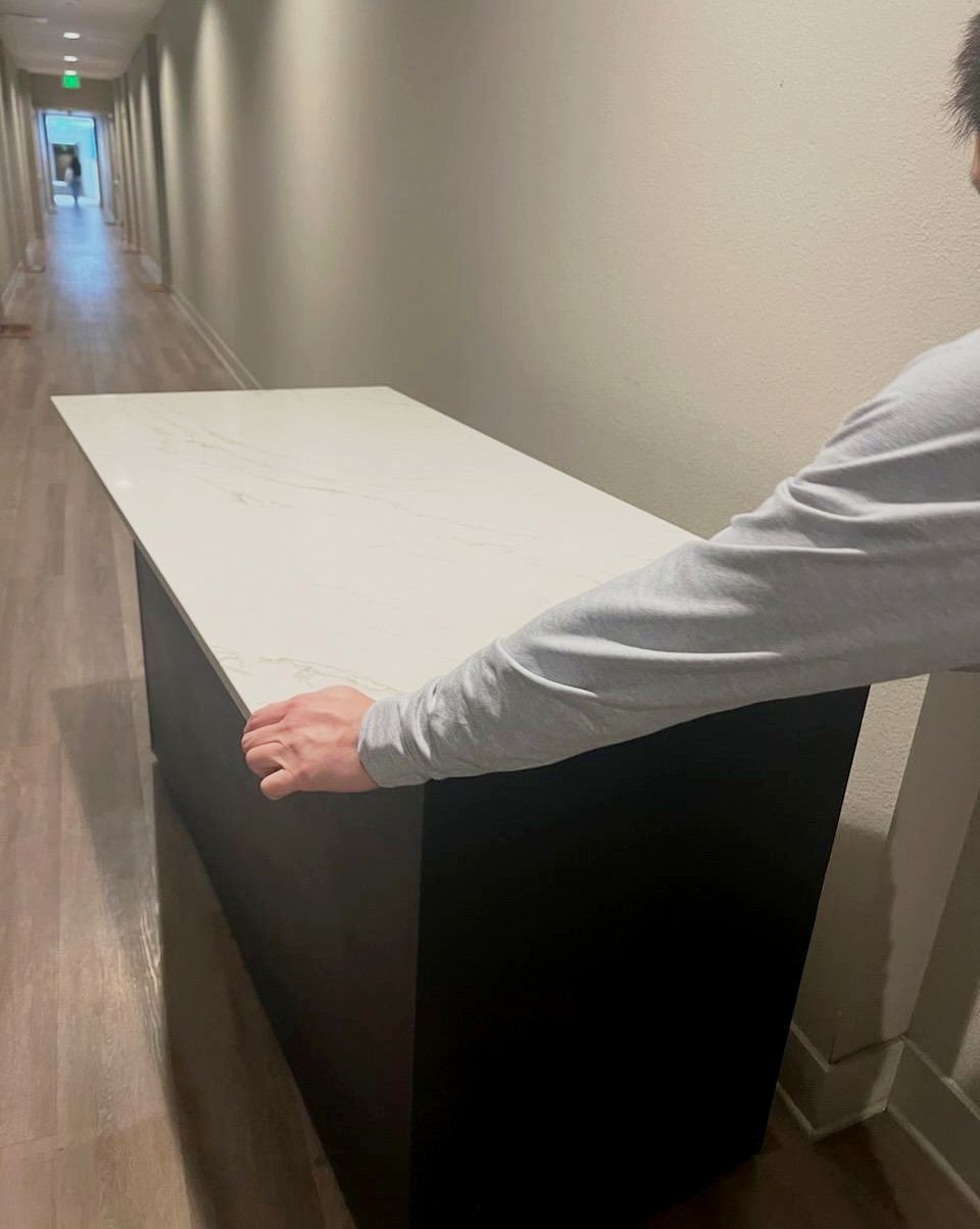 Mover carefully carrying a countertop through a hallway